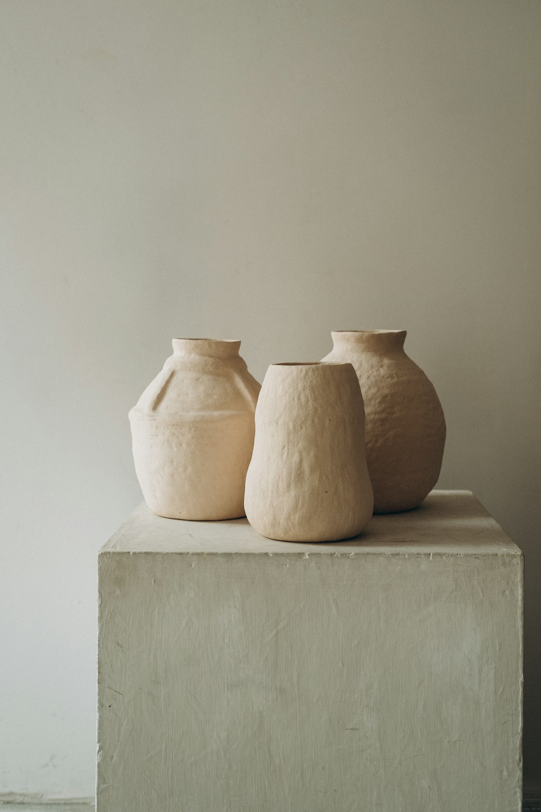 Three clay vases on a concrete table