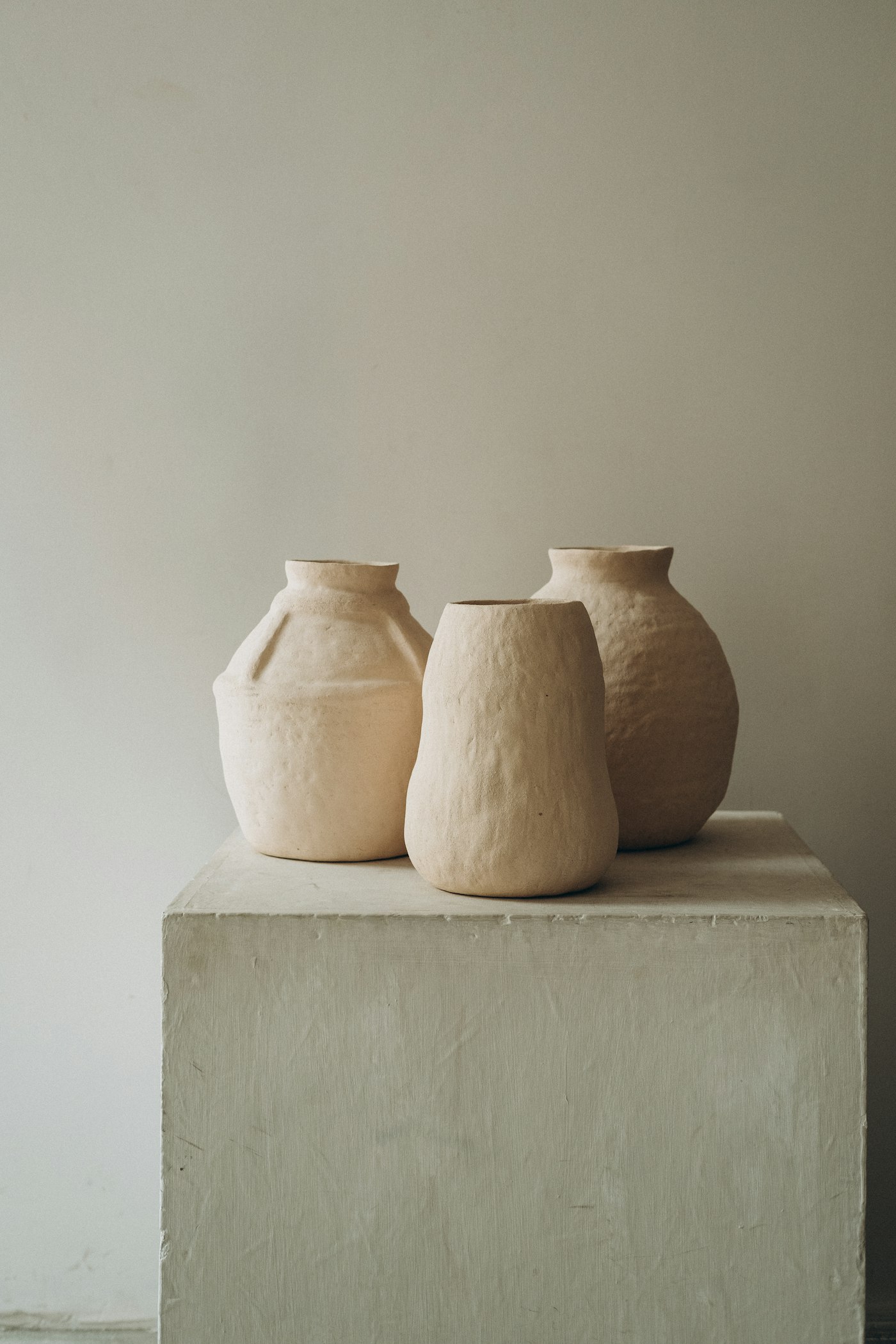 Three clay vases on a concrete table